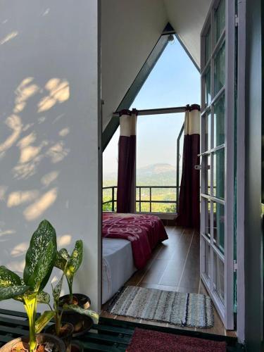 a bedroom with a bed and a large window at Casita Greens in Kondotti