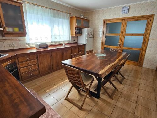 a kitchen with a wooden table and chairs in it at Santa Maria Goldcrest House in Vila do Porto