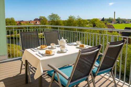 ein weißer Tisch mit Stühlen auf einem Balkon in der Unterkunft Weitblick in Schillig