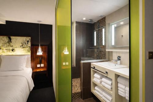 a hotel room with a bed and a sink at Hôtel de Brienne in Toulouse