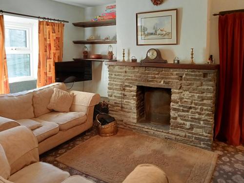 a living room with a couch and a fireplace at Le Farmhouse in Hawes