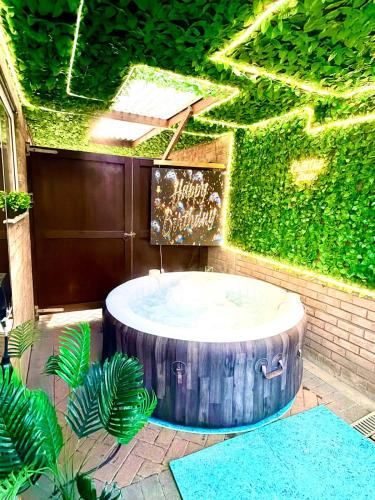 a round table in front of a wall with ivy at Hot Tube&Private Driveway&11 Guests Family&Contractors Bedford in Bedford