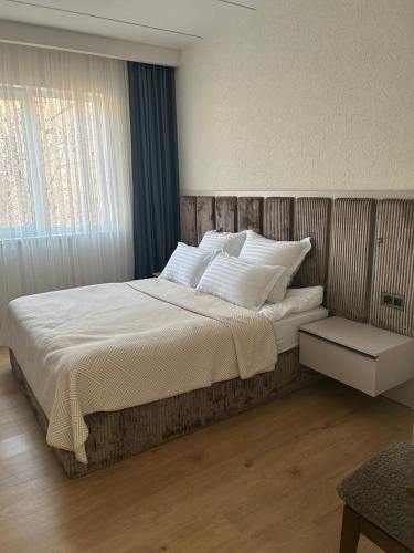 ギュムリにあるGhonakh Guesthouseの白い枕が置かれた大きなベッドのある寝室