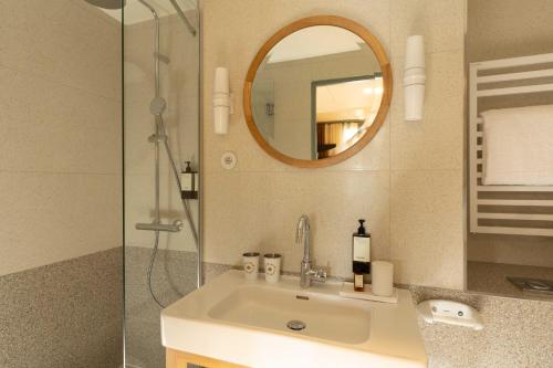 a bathroom with a sink and a shower and a mirror at Hôtel Casimir in Paris