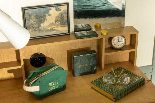 a wooden shelf with a clock and a book at Hôtel Casimir in Paris