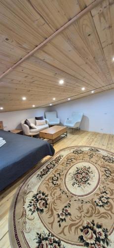 a bedroom with a bed and a couch and a rug at B apartment Рахів in Rakhiv