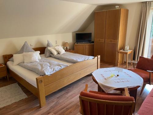 a living room with a bed and a table at Gästehaus Möschel in Weiler-Simmerberg