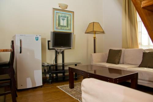 a living room with a couch and a tv at Natural Oak Apartments in Nairobi