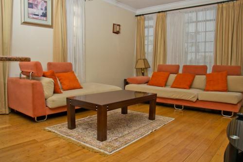 a living room with two couches and a coffee table at Natural Oak Apartments in Nairobi
