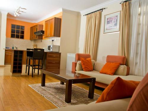 a living room with a couch and a table at Natural Oak Apartments in Nairobi