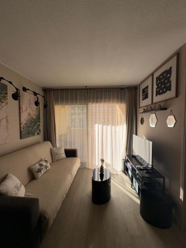 una sala de estar con un sofá y un televisor en Cannes Pool & Beach, en Cannes