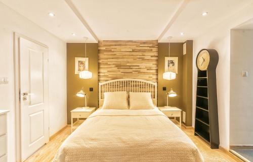 a bedroom with a large bed and two lamps at Willa Weneda in Gdynia