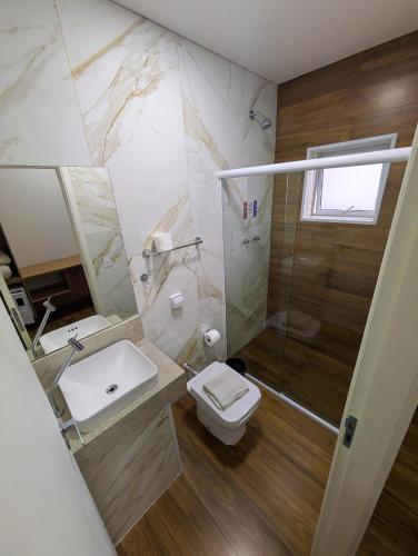 a bathroom with a toilet and a sink and a shower at Bonno Hotel Paulínia in Paulínia