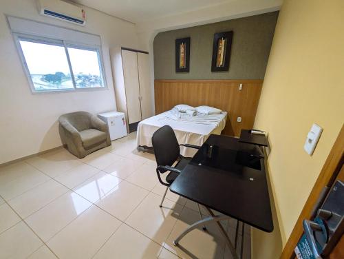 a room with a bed and a chair in it at Bonno Hotel Paulínia in Paulínia