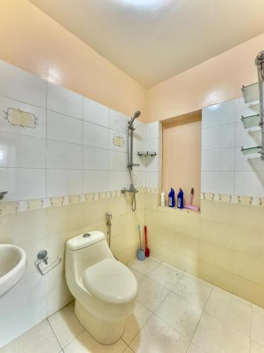 a bathroom with a toilet and a sink at Triluna Apartments in Pātan