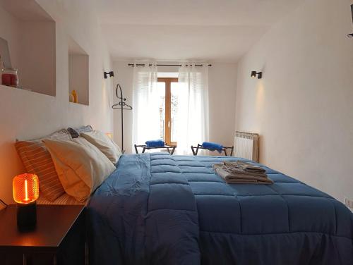 a bedroom with a blue bed with a table and chairs at Il cantuccio di Federico in Radicofani