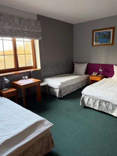 a hotel room with two beds and a table at Przystań nad Sołą in Bielany
