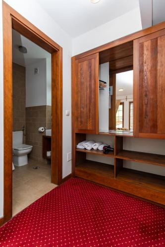 a bathroom with a toilet and a red rug at Garni Konak Hotel By Blanket Collection in Sarajevo