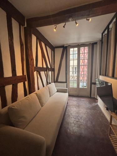 a living room with a white couch and a window at L'écrin Beauvoisine - Rouen Hyper Center in Rouen