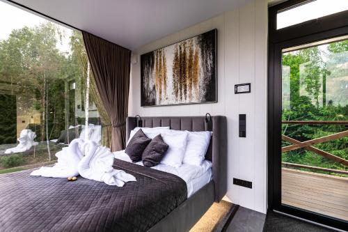 a bedroom with a bed with white sheets and a window at Luxury Resort Orava in Orava