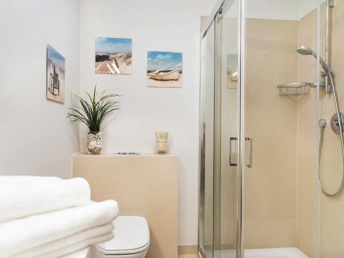 a bathroom with a shower and a toilet at VacationClub - Baltic Park Molo Apartment D203 in Świnoujście