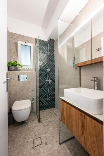 a bathroom with a sink and a toilet and a shower at Warmth & Charm Island Style in Kos