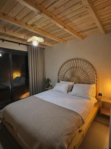a bedroom with a large bed with a wooden headboard at Çavdi Villa in Ardeşen