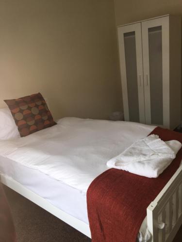 a bed with white sheets and a red blanket at The Horse and Jockey in Stapleford