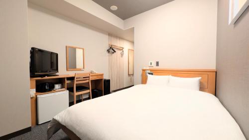 a hotel room with a bed and a television at Hotel Route-Inn Aomori Ekimae in Aomori