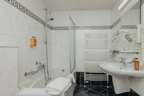 a white bathroom with a sink and a bath tub at Boutique Hotel Korana Srakovcic in Karlovac