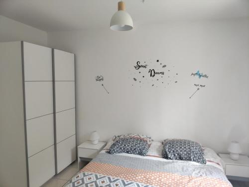 a bedroom with a bed with writing on the wall at Maison agréable, emplacement idéal in Sainte-Suzanne