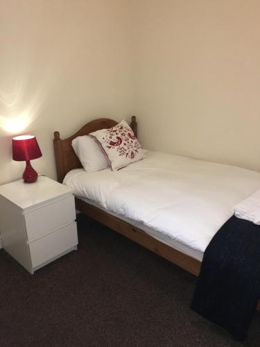 a bedroom with two beds and a lamp on a night stand at The Horse and Jockey in Stapleford