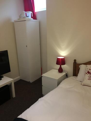 a bedroom with a bed and a desk with a lamp at The Horse and Jockey in Stapleford
