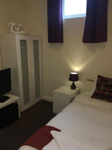 a bedroom with a bed and a television and a window at The Horse and Jockey in Stapleford