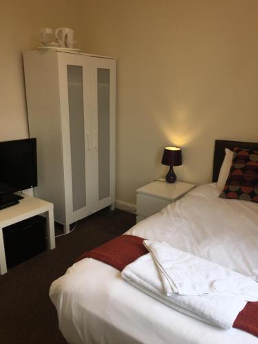 a bedroom with a bed and a tv and a bedskirtspectspectspectspects at The Horse and Jockey in Stapleford