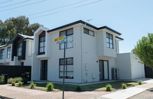 a white building with a street sign in front of it at Home Abroad in Ascot Park