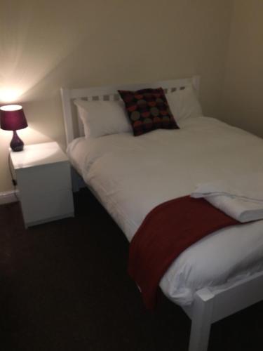a bedroom with two beds and a lamp on a table at The Horse and Jockey in Stapleford