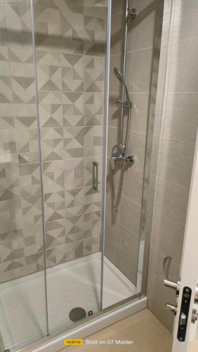 a shower with a glass door in a bathroom at Jardines del Mar 1 in El Borseral