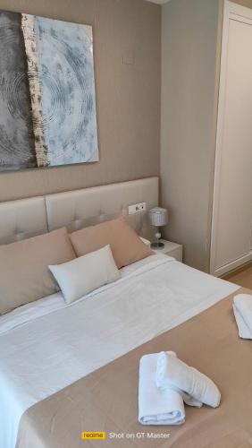 a bedroom with a large white bed with towels on it at Jardines del Mar 1 in El Borseral