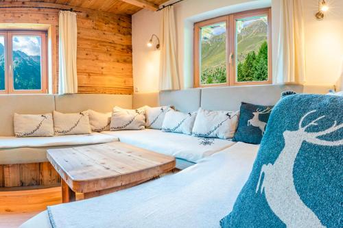 a room with two beds and a couch and windows at Berghütte Kneisl in Sölden