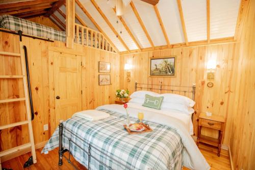 a bedroom with a bed in a wooden cabin at Little Pine Lodge At Saddlecreek in Thomasville
