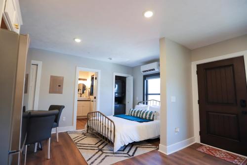 a bedroom with a bed and a table and chairs at Modern Queen Studio At The Victorian - Unit B in Muskegon