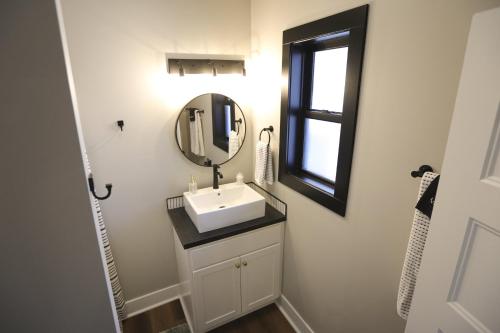 a bathroom with a sink and a mirror at Modern Queen Studio At The Victorian - Unit B in Muskegon