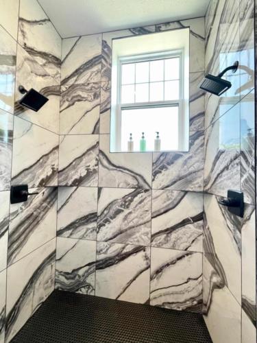 a bathroom with a marble wall with a window at Historical Boiler Maker Turns Vacation Destination in Muskegon