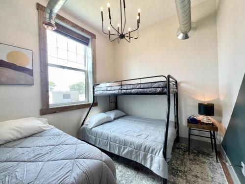 a bedroom with two bunk beds and a window at Historical Boiler Maker Turns Vacation Destination in Muskegon