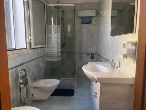 a bathroom with two sinks and a shower and a toilet at villa ingrassia in Favignana