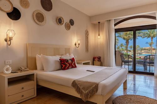a bedroom with a bed with a view of the ocean at Blend Elphistone Resort Marsa Alam in Abu Dabbab