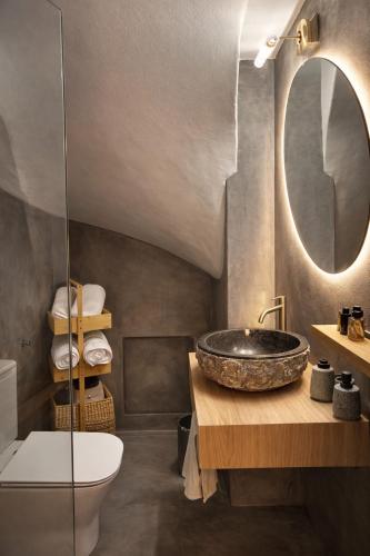 a bathroom with a sink and a toilet and a mirror at Aurora Apartments in Mytilene