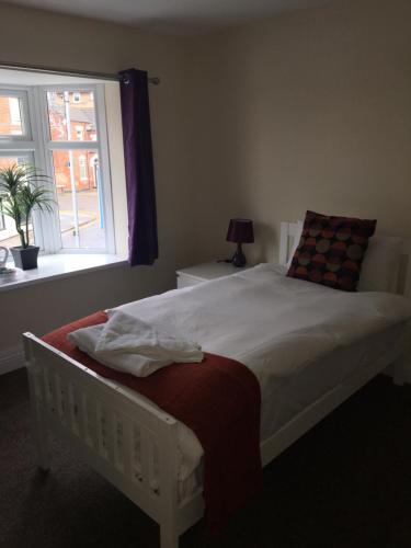 a bedroom with a white bed and a window at The Horse and Jockey in Stapleford
