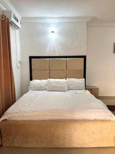 a bedroom with a large bed with white sheets at AG Sigma Apartments in Port Harcourt